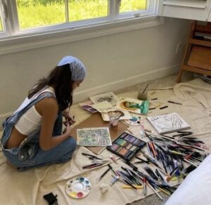Chica haciendo manualidades en el suelo